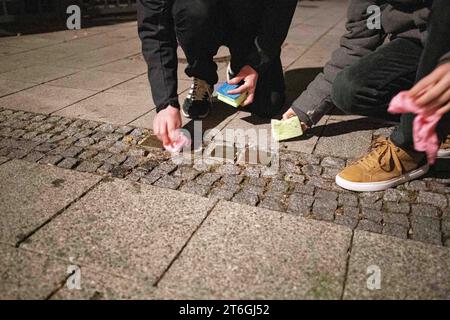 München, Deutschland. November 2023. Antifaschisten säubern Stolpersteine und legen Blumen und Kerzen am 9. November 2023 in München ab. Sie gedenken unter anderem an Olga Benario und Georg Elser. (Foto: Alexander Pohl/SIPA USA) Credit: SIPA USA/Alamy Live News Stockfoto