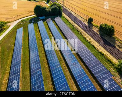 Bodenanlage mit Solarzellen und Solarmodulen auf dem Land neben einer Eisenbahnlinie Stockfoto