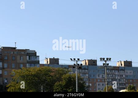 UKRAINE ODESSA, 4. Juli 2021: PPassagierflugzeug fliegt tief über Wohngebäude in Wohngegend in Flughafennähe. Starkes Brüllen eines Flugzeuges, der sich schnappt Stockfoto