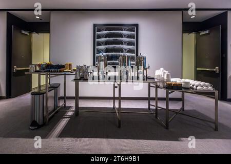 Ein Kaffee- und Snacktisch steht im Konferenzbereich des Radisson Blu Aqua Hotel in Chicago, Illinois, USA, über dem eine große Schwarz-Weiß-Fotografie der Zwillingstürme von Marina City hängt. Das Hotel befindet sich in den unteren Etagen des Aqua Tower, der 2009 von der Architektin Jeanne Gang entworfen wurde. Stockfoto