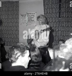 Etwa Ende der 1960er Jahre, historisch, eine weibliche Folk-Sängerin, die in einem Raum mit Gitarre sitzt. An der Wand hinter ihr festgeklemmt, werden die Sänger Jimmy Macbeath, Paddie Bell, Hamish Henderson am 20. Oktober mit Tregullion Jack & Barbara & Guests und Matt McGinn aufgeführt. Stockfoto