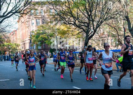 Die Läufer fahren am Sonntag, den 5. November 2023 beim TCS New York City Marathon durch Harlem in New York nahe der 22-km-Marke in der Nähe des Mount Morris Park. 50.000+ Teilnehmer liefen durch die fünf Bezirke und kämpften mit warmem Wetter. (© Richard B. Levine) Stockfoto