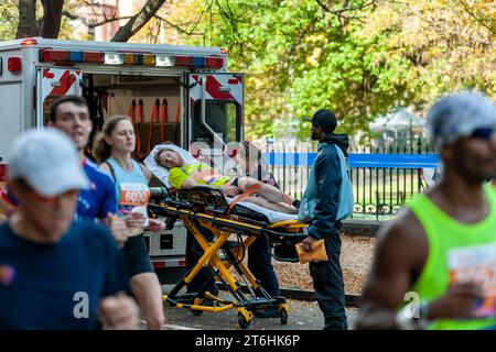 EMT-Läufer laden einen Läufer in ihren Krankenwagen, während die Läufer beim TCS New York City Marathon am Sonntag, den 5. November 2023, in der Nähe der 22-Meilen-Marke in der Nähe des Mount Morris Park durch Harlem in New York fahren. (© Richard B. Levine) Stockfoto