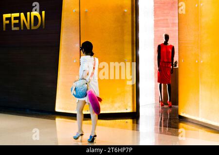 China, Shanghai, Mall Plaza 66 in Nanjing Lu, Chinesin spaziert vorbei an einer Modeboutique mit Schaufensterpuppe Stockfoto