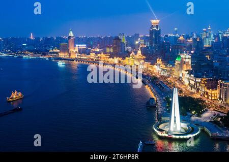 China, Shanghai, der Bund mit Maertyr Memorial Tower und das Bund Center im Hintergrund. Schiffe fahren auf dem Huangpu River Stockfoto