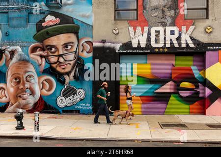 Junges Paar mit Kaffee und Hund vor Street Art, Bushwick, New York City, Nordamerika, USA, USA Stockfoto