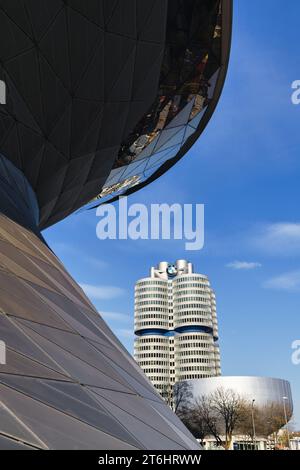 München, Deutschland - 05. April 2023: Blick von der BMW Welt auf das BMW Museum und den BMW Tower. BMW ist ein deutscher multinationaler Hersteller von Luxusfahrzeugen Stockfoto