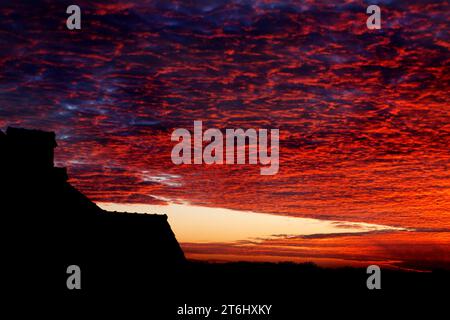 Wunderschöner farbenfroher, dramatischer Himmel mit Wolken bei Sonnenuntergang oder Sonnenaufgang. Heller farbenfroher Sonnenuntergang über Silhouetten von Wohngebäuden im Cottage Village. Stockfoto