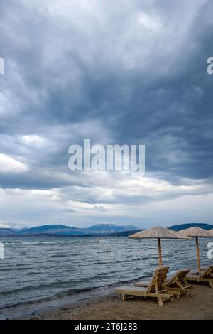 Kalamaki, Korfu, Griechenland, Sonnenliegen und Sonnenschirme am Kalamaki Strand im Nordosten der griechischen Insel Korfu, im Hintergrund das Festland von Albani Stockfoto