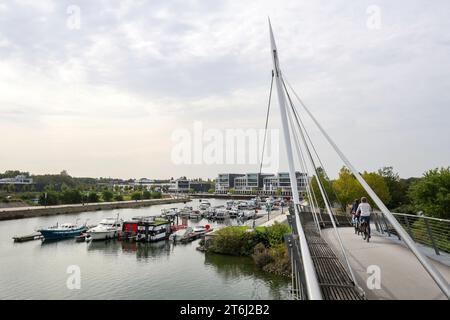 Gelsenkirchen, Nordrhein-Westfalen, Deutschland, Marina Graf Bismarck (auch Stoelting Marina), Marina im neuen Stadtteil Graf Bismarck, Standort der ehemaligen Zeche Graf Bismarck, am Rhein-Herne-Kanal im Landkreis Gelsenkirchen Bismarck. Radfahrer fahren über die Graf Bismarck Hafenbrücke. Stockfoto