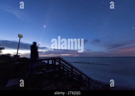 Person strahlt Taschenlampe am Sternenhimmel, Ostseeinsel Mon, Dänemark Stockfoto