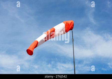 Weiß-rote Windsocke gegen blauen Himmel, bewölkt, Windfahne, Deutschland Stockfoto