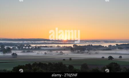 Frühmorgendlicher Nebel mit Sonnenaufgang über dem Radolfzeller Aachried, dahinter der Bodensee mit der Stadt Radolfzell, Landkreis Konstanz Stockfoto