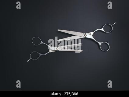 Professionelle Haarschneideschere. Offene Friseurschere auf schwarzem Hintergrund. Professionelles Werkzeug für Friseurscheren Stockfoto