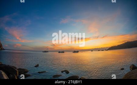 Tauch- und Fischerboote vor der Küste vor der Insel Ko Tao in Thailand vor Anker, unter einer strahlenden Sonne. Stockfoto