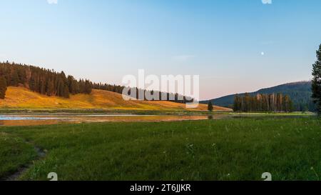 Der Yellowstone River fließt durch das Hayden Valley bei Sunset im Yellowstone-Nationalpark, USA Stockfoto