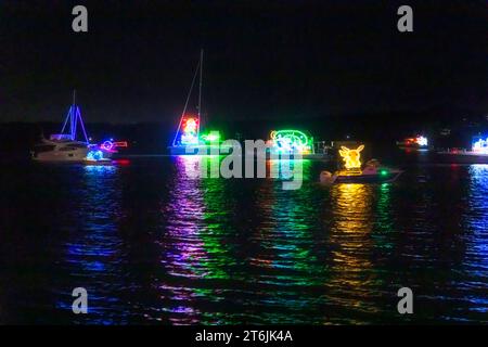 Hell beleuchtete Boote und Yachten auf Lake Macquarie während der Fluoro Nachtlichtshow und Festival in Australien. Stockfoto