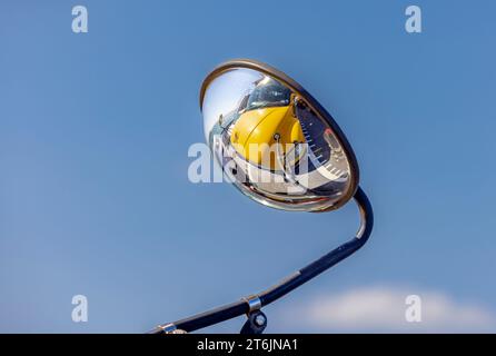 Detail eines konvexen Spiegels in einem Schulbus, der das vordere Ende des Busses reflektiert Stockfoto