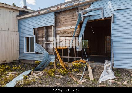 Teilweise abgerissenes Gebäude mit blauer Vinylverkleidung. Stockfoto