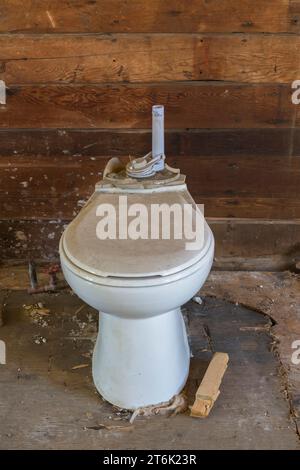 Alte Toilette mit Wassertank im verlassenen Geschäftsgebäude entfernt. Stockfoto