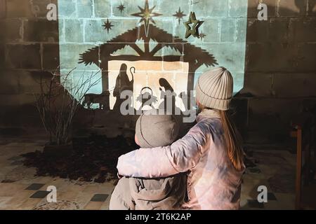 Kinder schauen sich die weihnachtskrippe mit Joseph Maria und klein an Jesus Stockfoto