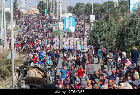 Palästinensische Familien, die aus Gaza-Stadt und anderen Teilen des nördlichen Gazastreifens in Richtung Süden fliehen, gehen entlang einer Straße zwischen den anhaltenden Kämpfen zwischen Israel und der palästinensischen Hamas-Bewegung. Tausende Palästinenser sind vor schweren Kämpfen zwischen Hamas-Kämpfern und dem israelischen Militär in Gaza-Stadt geflohen, einen Monat nachdem die Hamas im Gazastreifen am 7. Oktober in den Süden Israels einmarschiert war. Stockfoto