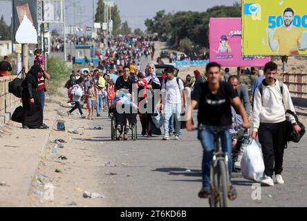 Palästinensische Familien, die aus Gaza-Stadt und anderen Teilen des nördlichen Gazastreifens in Richtung Süden fliehen, gehen entlang einer Straße zwischen den anhaltenden Kämpfen zwischen Israel und der palästinensischen Hamas-Bewegung. Tausende Palästinenser sind vor schweren Kämpfen zwischen Hamas-Kämpfern und dem israelischen Militär in Gaza-Stadt geflohen, einen Monat nachdem die Hamas im Gazastreifen am 7. Oktober in den Süden Israels einmarschiert war. Stockfoto