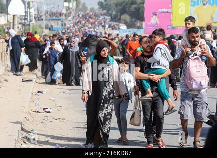 Palästinensische Familien, die aus Gaza-Stadt und anderen Teilen des nördlichen Gazastreifens in Richtung Süden fliehen, gehen entlang einer Straße zwischen den anhaltenden Kämpfen zwischen Israel und der palästinensischen Hamas-Bewegung. Tausende Palästinenser sind vor schweren Kämpfen zwischen Hamas-Kämpfern und dem israelischen Militär in Gaza-Stadt geflohen, einen Monat nachdem die Hamas im Gazastreifen am 7. Oktober in den Süden Israels einmarschiert war. Stockfoto