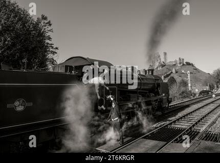 Dampfeisenbahn, die durch den Bahnhof Corfe mit Schloss Corfe fährt Stockfoto