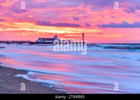 Bournemouth Beach lebhafter Sonnenaufgang mit Bournemouth Pier in der Ferne Stockfoto