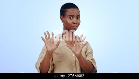 Schwarze Frau, Porträt und Hände für Nein, Ablehnung oder Ablehnung isoliert vor blauem Studiohintergrund. Das Gesicht einer besorgten afrikanischen Frau oder eines Modells Stockfoto