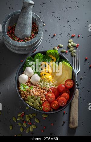 Gesunder Salat mit Avocado, Käse, Tomaten und Grütze. Schüssel mit Gemüse für fitte Menschen. Stockfoto