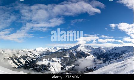 Panorama des schneebedeckten Bergtals in den österreichischen alpen mit blauem Himmel mit hellen Wolken und Berggipfeln im Hintergrund Stockfoto