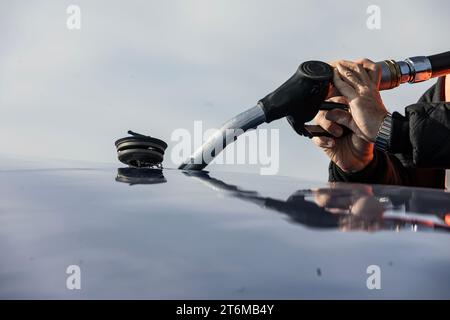 Betanken des Flugzeugs. Das FBO betankt das Geschäftsflugzeug vor dem Abflug. Nahaufnahme einer Hand mit einer Panzerpistole. Konzept für Unternehmensflieger. Stockfoto