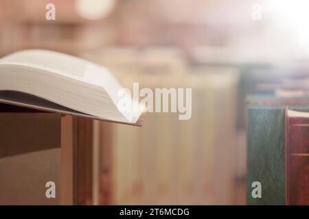 Bild eines offenen antiken Buches auf einem Stapel von Büchern mit Glitzerhintergrund. Stockfoto
