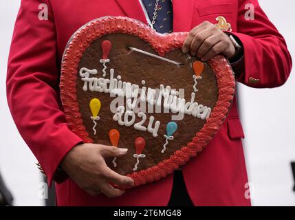 München, Deutschland. November 2023. 11. November 2023, Bayern, München: Ein Mitglied der Narhalla hält ein Lebkuchenherz mit der Inschrift „Fasching in München 2024“ bei der Präsentation von Friedrich I. und Katharina I. als offizieller Prinz und Prinzessin des Narhalla Karnevalsvereins auf dem Viktualienmarkt. Die Präsentation markiert den Beginn der Karnevalssaison in der Landeshauptstadt. Foto: Uwe Lein/dpa Credit: dpa Picture Alliance/Alamy Live News Stockfoto