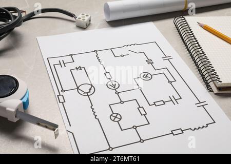 Schaltplan, Drähte, Maßband und Bürobedarf auf weißem Holztisch, Großaufnahme Stockfoto