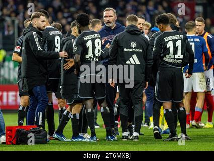 11. November 2023, Schleswig-Holstein, Kiel: Fußball: Bundesliga 2, Holstein Kiel - Hamburger SV, Spieltag 13, Holstein Stadium. Hamburger Trainer Tim Walter steht nach dem Spiel zwischen seinen Spielern. Foto: Axel Heimken/dpa - WICHTIGER HINWEIS: Gemäß den Vorschriften der DFL Deutschen Fußball-Liga und des DFB Deutschen Fußball-Bundes ist es verboten, im Stadion und/oder des Spiels aufgenommene Fotografien in Form von sequenziellen Bildern und/oder videoähnlichen Fotoserien zu verwenden oder zu nutzen. Stockfoto