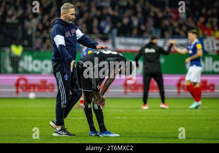 11. November 2023, Schleswig-Holstein, Kiel: Fußball: Bundesliga 2, Holstein Kiel - Hamburger SV, Spieltag 13, Holstein Stadium. Hamburger Trainer Tim Walter gibt der Hamburger Bäckerei Jatta nach dem Spiel einen Schlag. Foto: Axel Heimken/dpa - WICHTIGER HINWEIS: Gemäß den Vorschriften der DFL Deutschen Fußball-Liga und des DFB Deutschen Fußball-Bundes ist es verboten, im Stadion und/oder des Spiels aufgenommene Fotografien in Form von sequenziellen Bildern und/oder videoähnlichen Fotoserien zu verwenden oder zu nutzen. Stockfoto