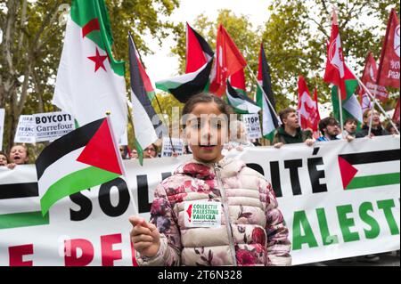 Toulouse, Frankreich. November 2023. Ein junges Mädchen mit palästinensischer Flagge, vor der Prozession, Solidarität mit dem palästinensischen Volk. Demonstration für den Frieden in Gaza, gegen die Massaker und Aufruf zu einem sofortigen Waffenstillstand. Verschiedene Gewerkschaften, darunter CGT, F.S.U le NPA, LFI und verschiedene palästinensische Kollektive, darunter Collectif Palestine Vaincra. Frankreich, Toulouse 11. November 2023. Foto: Patricia Huchot-Boissier/ABACAPRESS. Quelle: Abaca Press/Alamy Live News Stockfoto