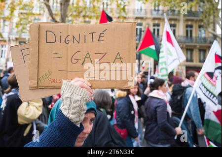 Toulouse, Frankreich. November 2023. Eine Frau hält ein Plakat, würde = Gaza, freies Palästina, in der Prozession. Demonstration für den Frieden in Gaza, gegen die Massaker und Aufruf zu einem sofortigen Waffenstillstand. Verschiedene Gewerkschaften, darunter CGT, F.S.U le NPA, LFI und verschiedene palästinensische Kollektive, darunter Collectif Palestine Vaincra. Frankreich, Toulouse 11. November 2023. Foto: Patricia Huchot-Boissier/ABACAPRESS. Quelle: Abaca Press/Alamy Live News Stockfoto