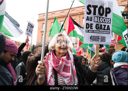 Toulouse, Frankreich. November 2023. Eine Frau in der Prozession mit einem Plakat, stoppt die Gaza-Blockade und Bombenangriffe. Demonstration für den Frieden in Gaza, gegen die Massaker und Aufruf zu einem sofortigen Waffenstillstand. Verschiedene Gewerkschaften, darunter CGT, F.S.U le NPA und verschiedene palästinensische Kollektive, darunter Collectif Palestine Vaincra. Frankreich, Toulouse 11. November 2023. Foto: Patricia Huchot-Boissier/ABACAPRESS. Quelle: Abaca Press/Alamy Live News Stockfoto