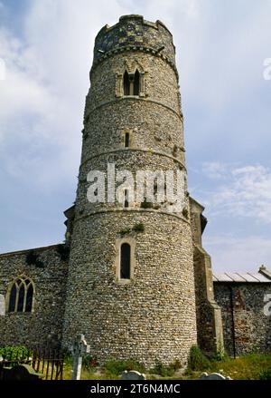 Blick E auf den sächsischen (sächsisch-normannischen) Rundturm der St. Mary's Church, Haddiscoe, Norfolk, England, Großbritannien. Feuerstein mit Kalksteinverbänden, 15. Schachwerk. Stockfoto