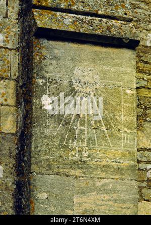 Eine mittelalterliche oder spätere Sonnenuhr auf der Südwestseite des Kirchenschiffs der St Laurence’s Church, Longney, Gloucestershire, England, Großbritannien. Stockfoto