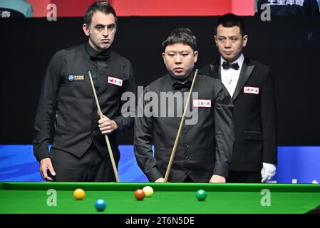 (231111) -- TIANJIN, 11. November 2023 (Xinhua) -- Zhang Anda (C) und Ronnie O'Sullivan (R) schauen sich im Halbfinale zwischen Zhang Anda aus China und Ronnie O'Sullivan aus England bei der Snooker-Weltmeisterschaft 2023 in der nordchinesischen Gemeinde Tianjin am 11. November 2023 an. (Xinhua/Li Ran) Stockfoto