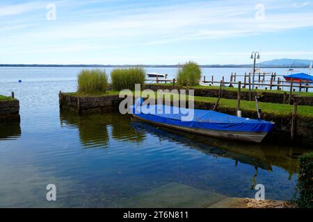 Eine malerische Aussicht mit einem alten Fischerboot auf der Insel Frauenchiemsee oder Fraueninsel auf dem Chiemsee an einem sonnigen Oktobertag in Bayern (Deutschland) Stockfoto