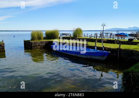 Eine malerische Aussicht mit einem alten Fischerboot auf der Insel Frauenchiemsee oder Fraueninsel auf dem Chiemsee an einem sonnigen Oktobertag in Bayern (Deutschland) Stockfoto