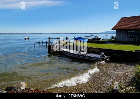 Eine malerische Aussicht mit einem alten Fischerboot auf der Insel Frauenchiemsee oder Fraueninsel auf dem Chiemsee an einem sonnigen Oktobertag in Bayern (Deutschland) Stockfoto