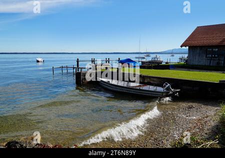 Eine malerische Aussicht mit einem alten Fischerboot auf der Insel Frauenchiemsee oder Fraueninsel auf dem Chiemsee an einem sonnigen Oktobertag in Bayern (Deutschland) Stockfoto