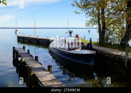 Eine malerische Aussicht mit einem alten Fischerboot auf der Insel Frauenchiemsee oder Fraueninsel auf dem Chiemsee an einem sonnigen Oktobertag in Bayern (Deutschland) Stockfoto